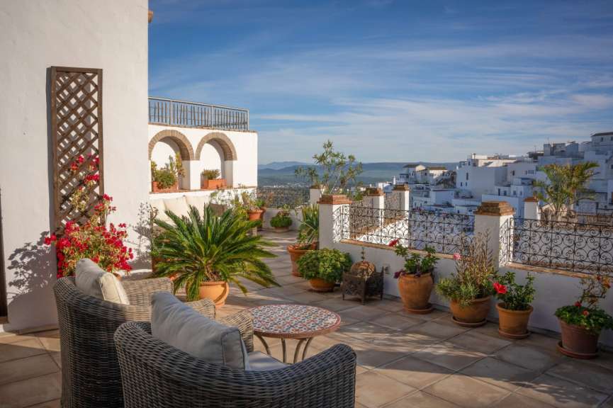 Eine Terrasse mit Stühlen und einem Tisch mit Blumentöpfen