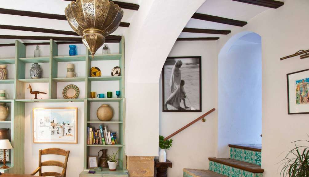 Ein Wohnzimmer mit Bücherregalen und Bildern an der Wand