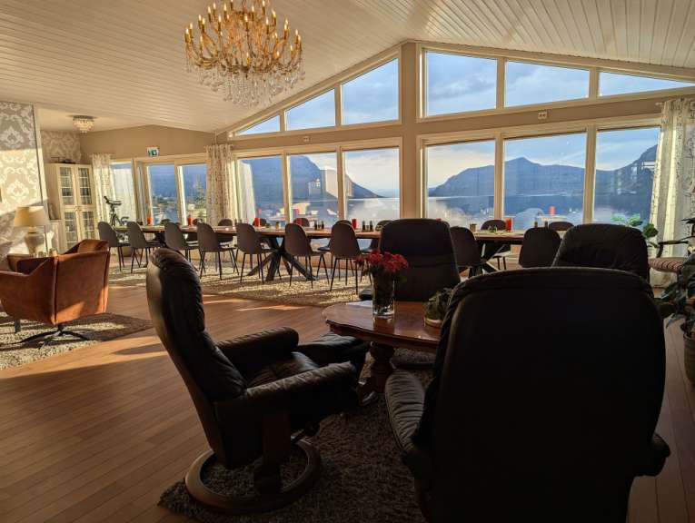 Ein Wohnzimmer mit vielen Stühlen und einem Kronleuchter