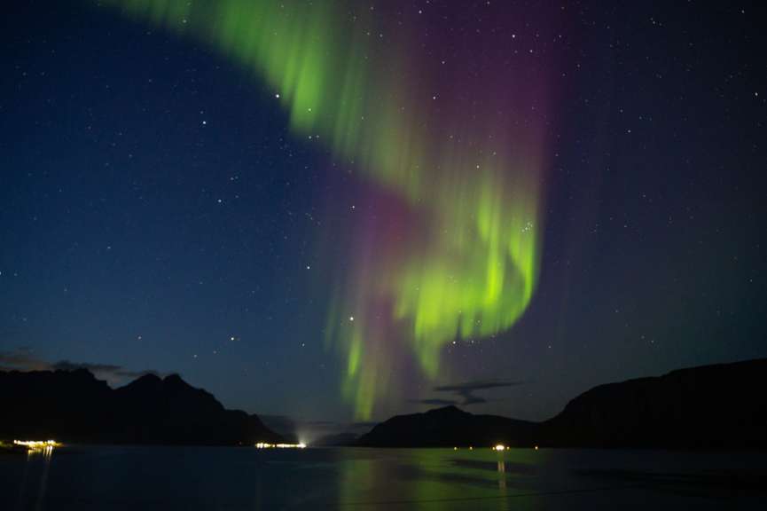 Das Nordlicht scheint in einem dunklen Himmel über einem See