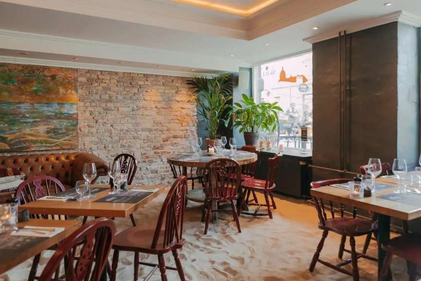 Tische und Stühle in einem Restaurant mit einem Gemälde an der Wand