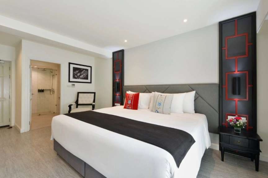Ein Hotelzimmer mit einem großen Bett und einem Stuhl