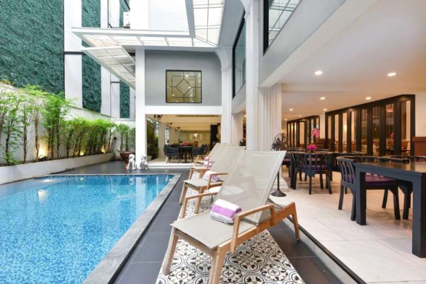 Ein Hotel mit einem Swimmingpool und einem Tisch und Stühlen