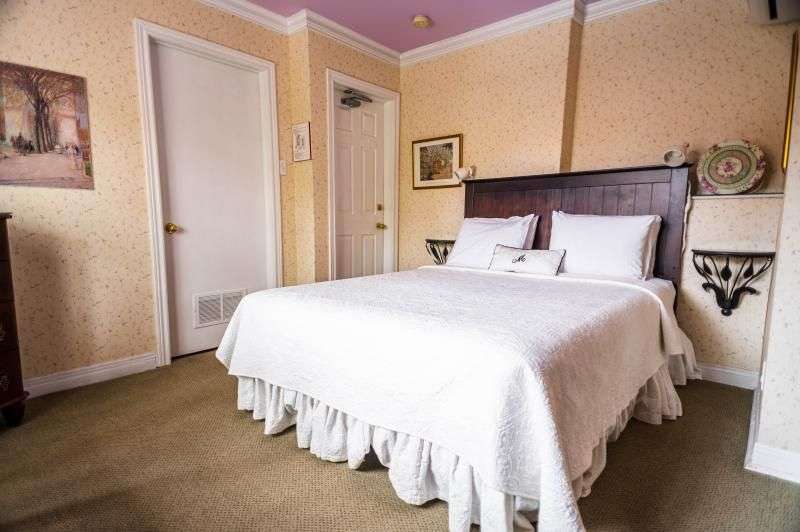 Ein Schlafzimmer mit einem Bett und einem Gemälde an der Wand