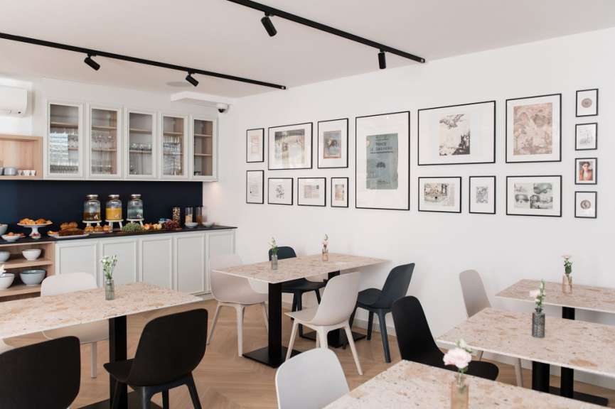 Ein Esszimmer mit Tischen und Stühlen und Bildern an der Wand