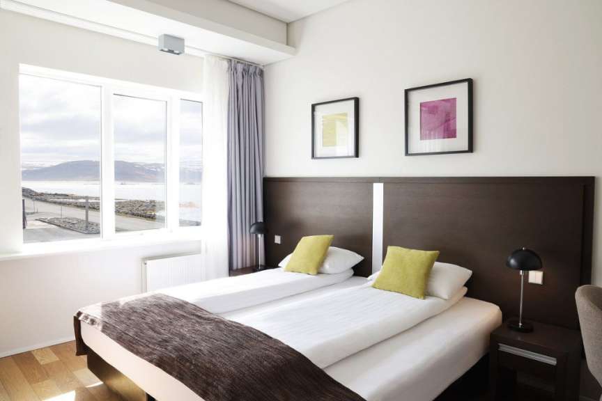 Ein Hotelzimmer mit zwei Betten und einem großen Fenster