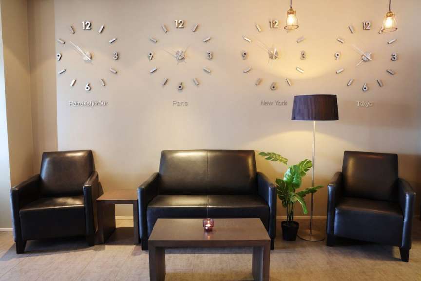 Ein Wohnzimmer mit Couch und Stühlen und Uhren an der Wand