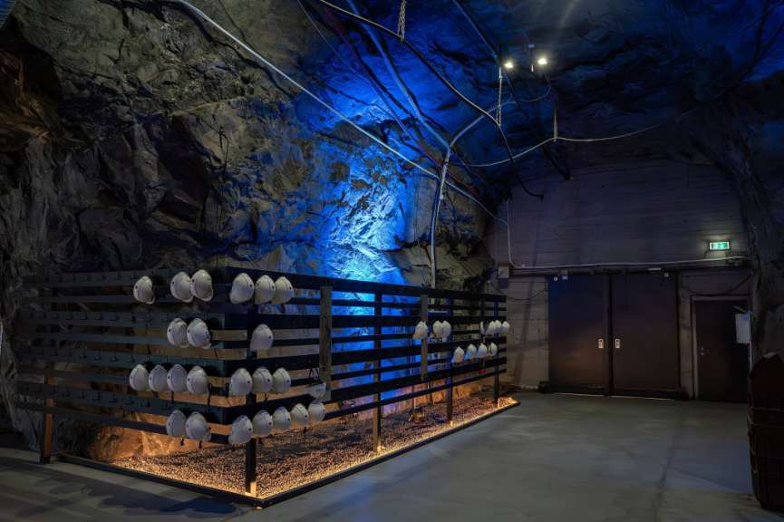 Eine Reihe von Hüten hängt an einem Zaun in einer Höhle