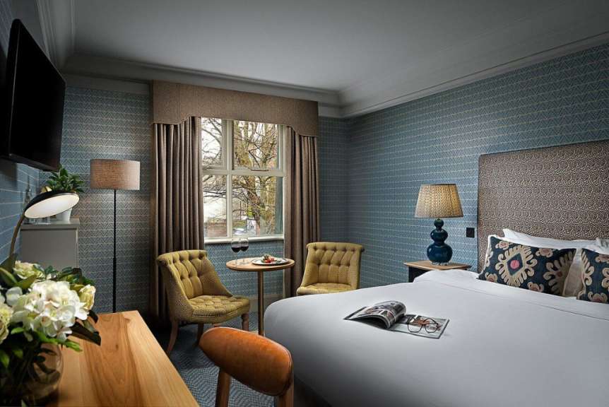 Ein Hotelzimmer mit einem Bett und zwei Stühlen