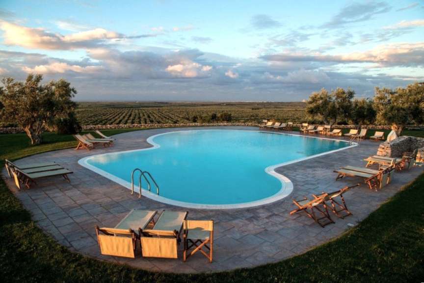 Ein großer Pool mit Liegestühlen und Stühlen um ihn herum