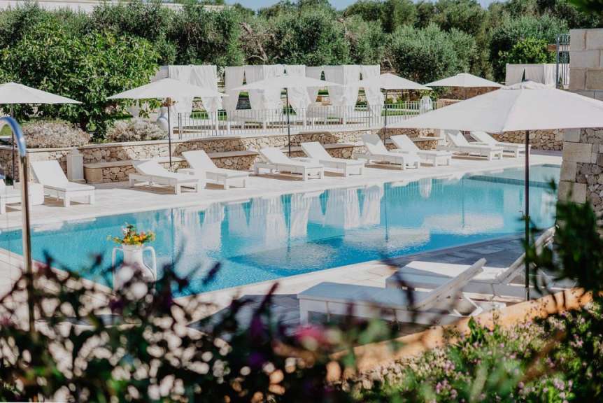Liegestühle und Sonnenschirme um einen großen Swimmingpool