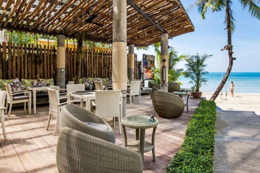 Ein Restaurant mit Tisch und Stühlen auf einem Holzdeck
