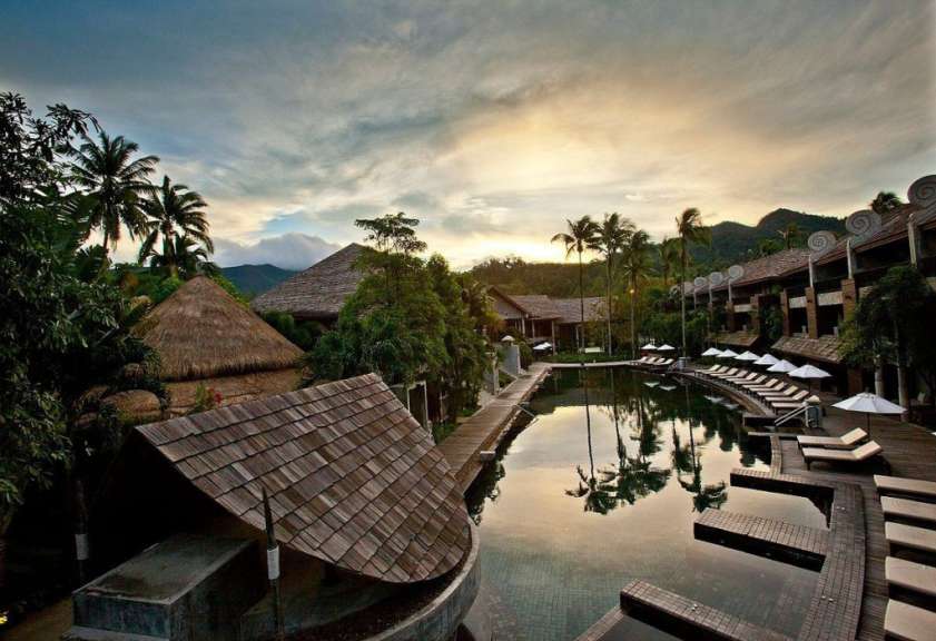 Ein Hotel mit einem großen Pool und vielen Sonnenschirmen