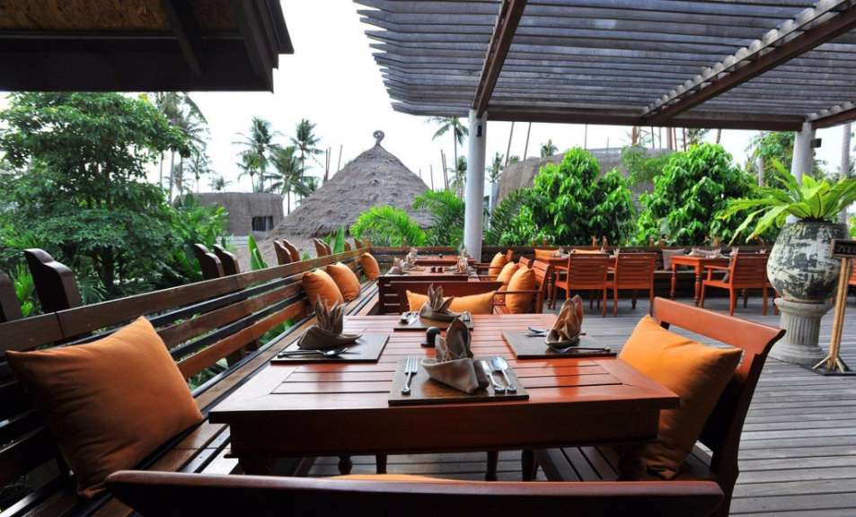 Ein Restaurant mit Holztischen und Stühlen auf einem Deck