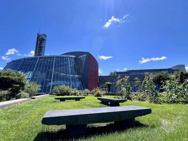 Bänke im Gras vor einem großen Gebäude