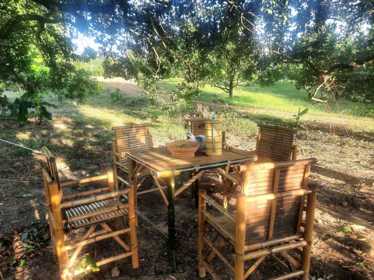 Ein Tisch und Stühle aus Bambus in einem Feld