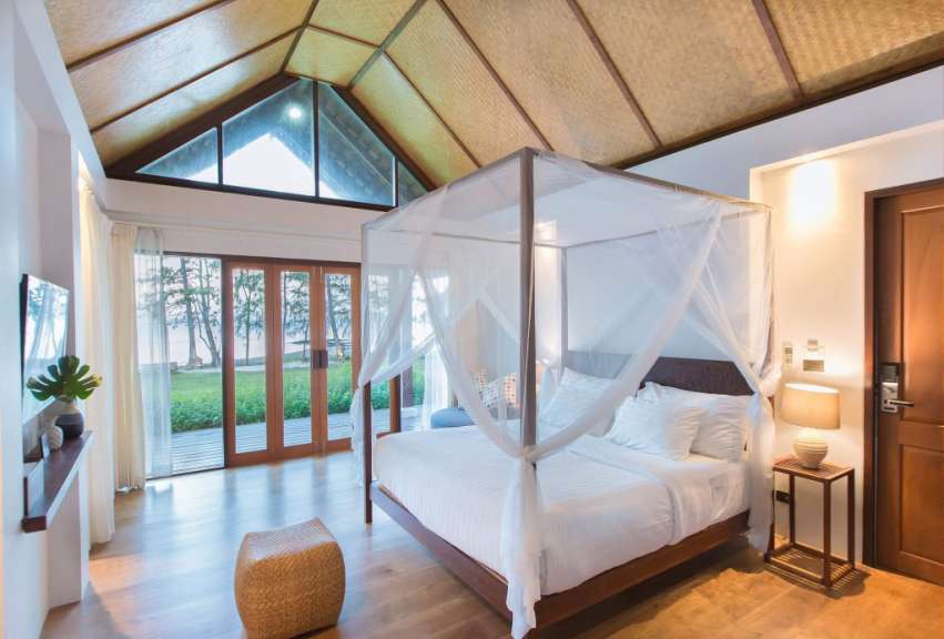 Ein Schlafzimmer mit Himmelbett und vielen Fenstern