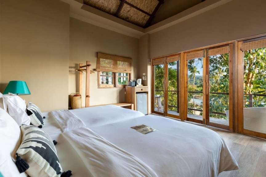 Ein Schlafzimmer mit zwei Betten und vielen Fenstern