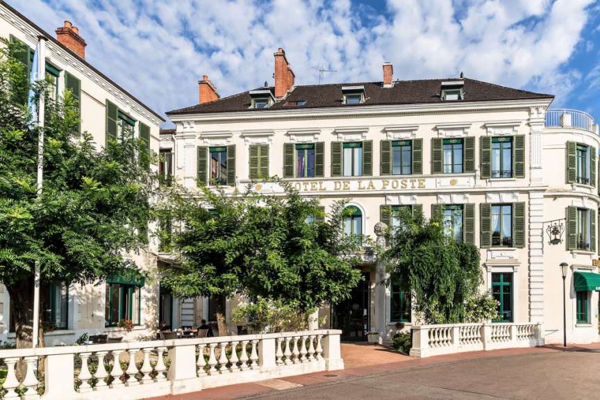 Ein großes weißes Gebäude mit dem Namen Hotel de la poste darauf