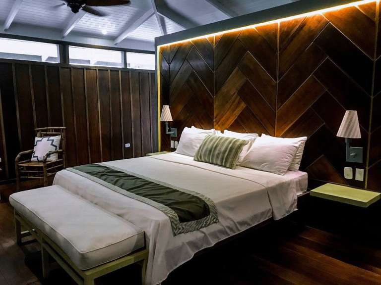 Ein schön eingerichtetes Schlafzimmer mit einem Holzbett und einer Holzwand.