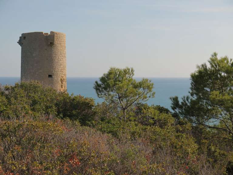 Ein Turm steht auf einem Hügel mit Blick auf das Meer