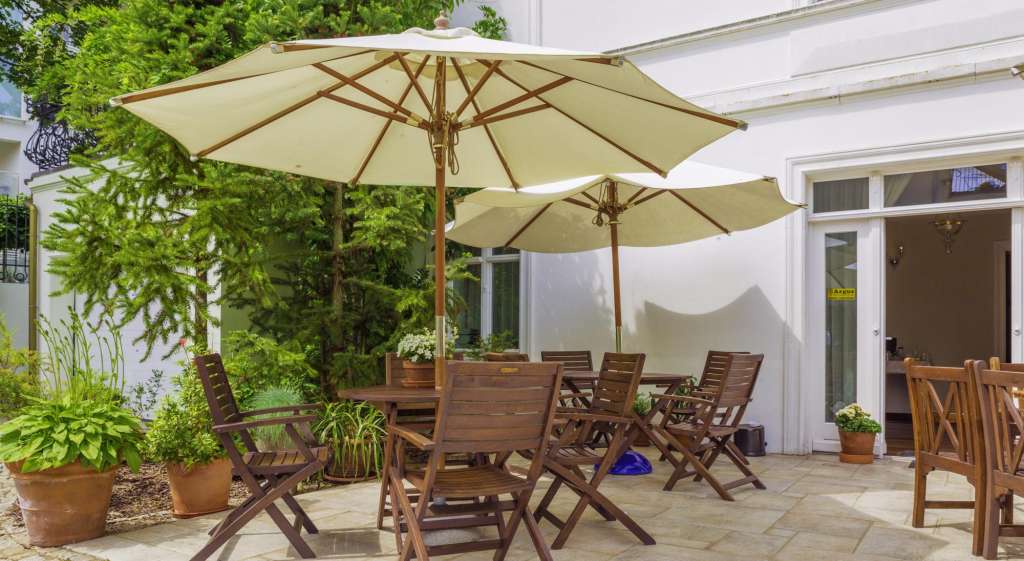 Eine Terrasse mit einem Tisch und Stühlen und zwei Sonnenschirmen