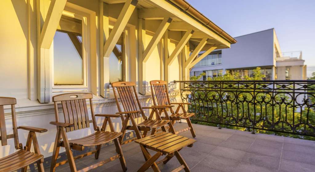 Eine Reihe von Holzstühlen sitzt auf einem Balkon