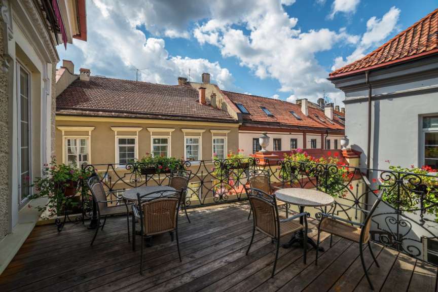 Ein Holzbalkon mit einem Tisch und Stühlen darauf