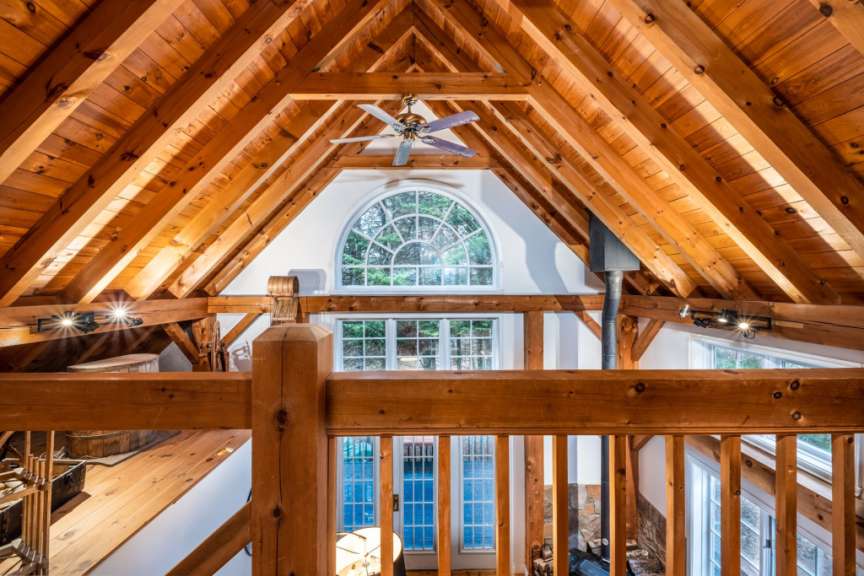 Eine Holzdecke mit einem Deckenventilator und einem großen Fenster