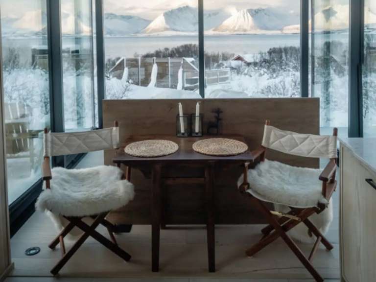 Ein Tisch und Stühle in einem Raum mit Blick auf den Schnee