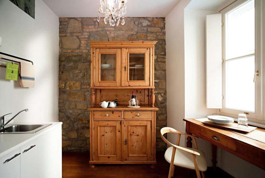 Eine kleine Küche mit einem Holzschrank und einem Stuhl