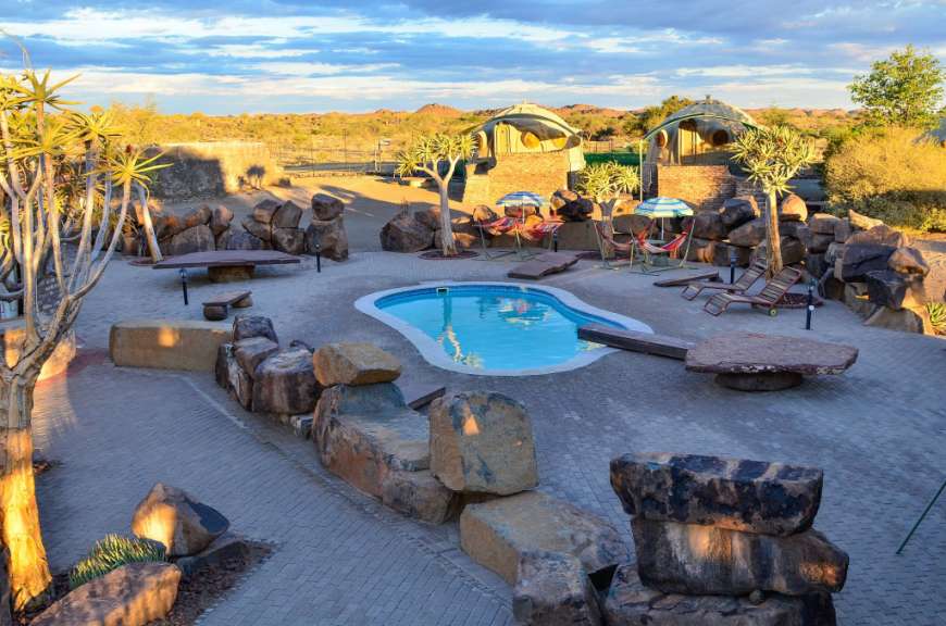 Ein großer Pool mit Liegestühlen und Sonnenschirmen davor