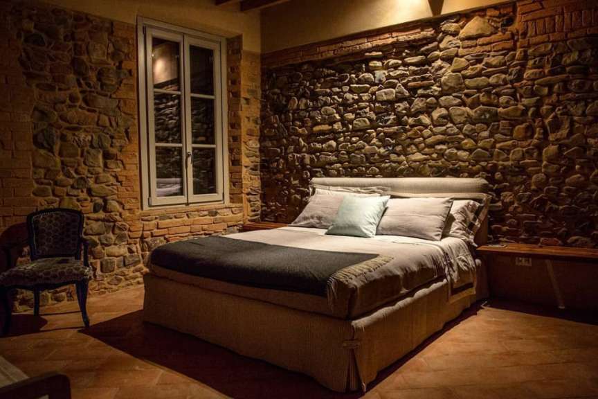 Ein Schlafzimmer mit einem Bett und einer Steinmauer