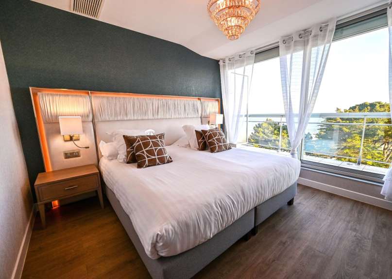 Ein Hotelzimmer mit einem großen Bett und einem großen Fenster