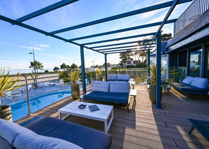 Ein Wohnzimmer mit einer Couch und einem Tisch neben einem Swimmingpool