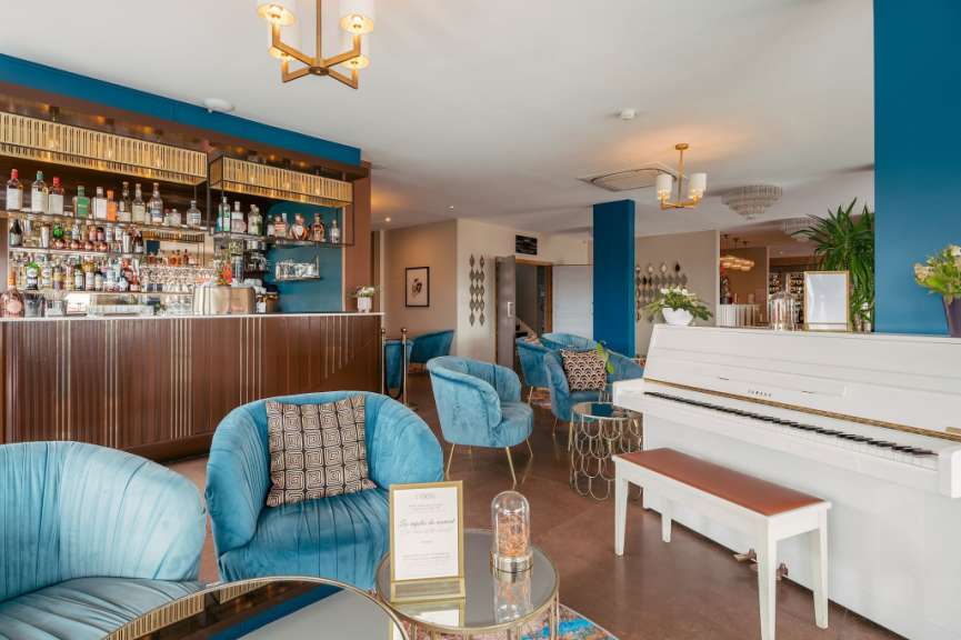 Ein Wohnzimmer mit blauen Stühlen und einem weißen klavier