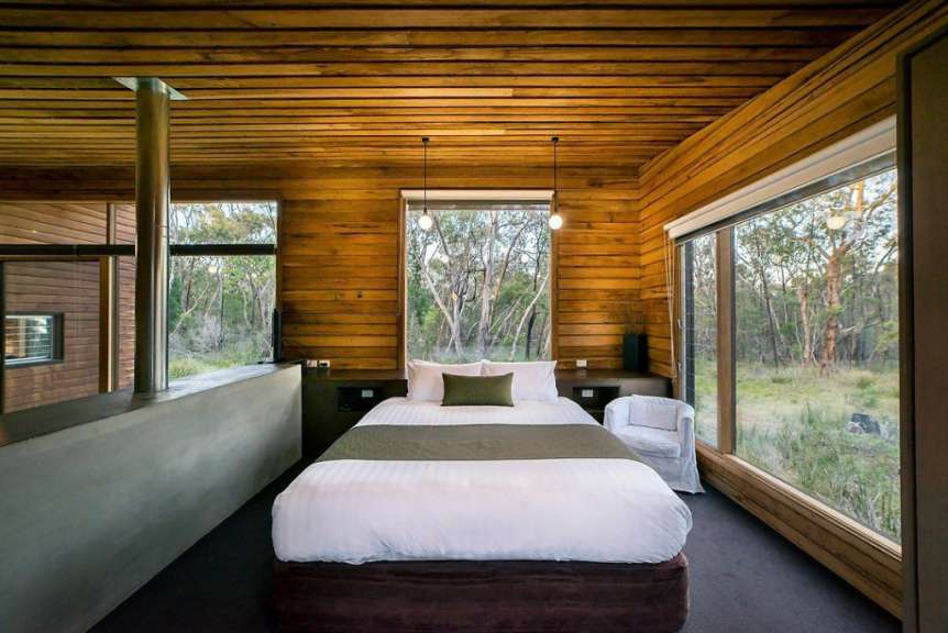 Ein Schlafzimmer mit einem Bett und vielen Fenstern