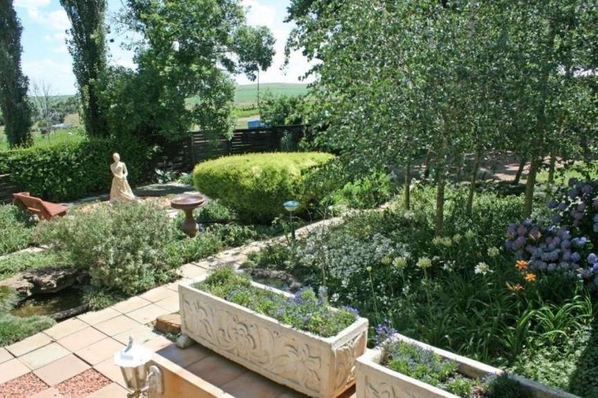 Ein Garten mit vielen Blumen und einer Statue