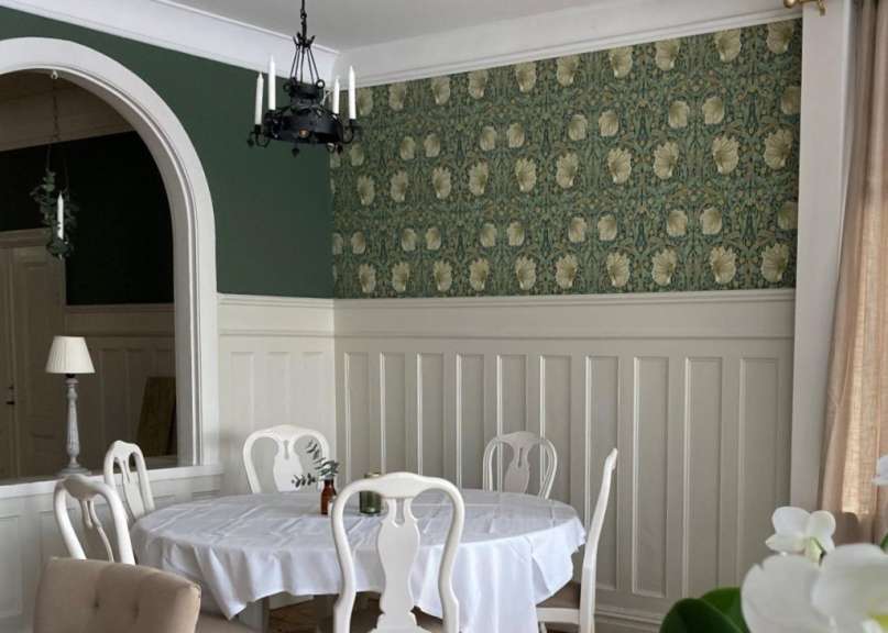 Ein Esszimmer mit einem weißen Tisch und weißen Stühlen