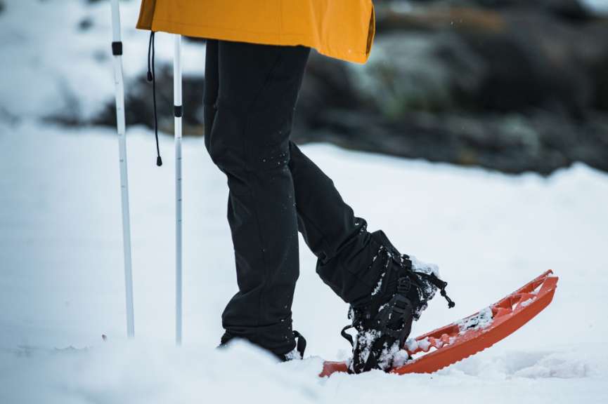 Eine Person geht mit Schneeschuhen durch den Schnee