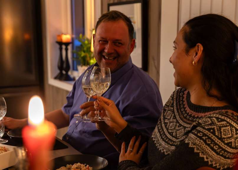 Ein Mann und eine Frau stoßen mit Weingläsern an