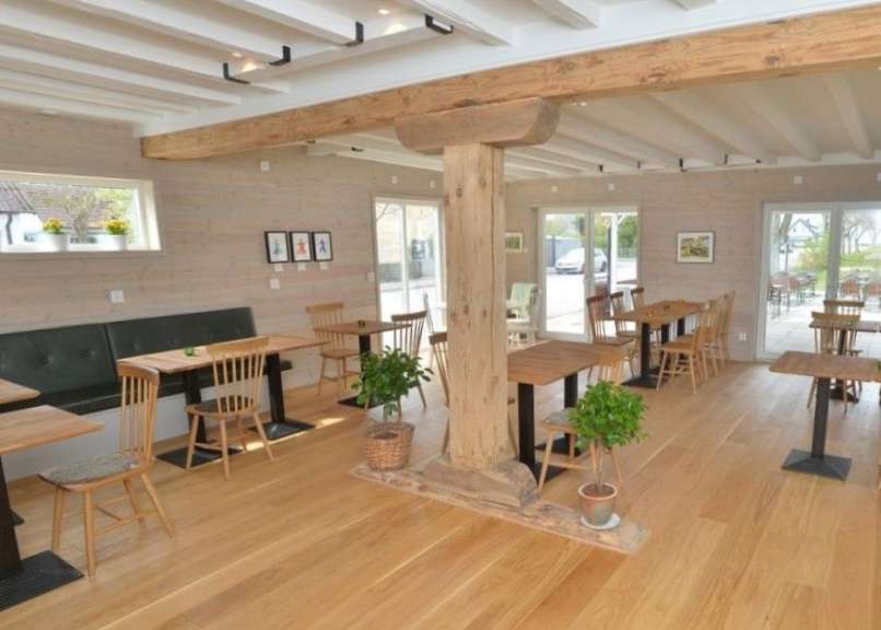 Ein Esszimmer mit vielen Holztischen und Stühlen