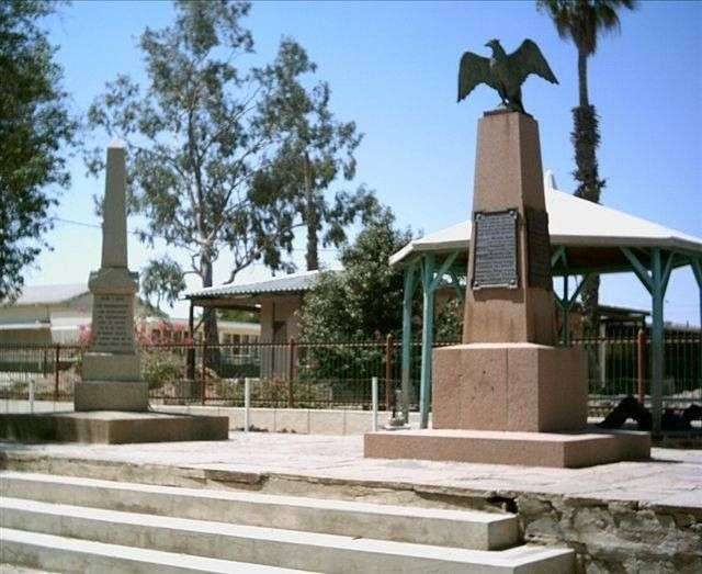Eine Statue eines Adlers sitzt auf einem Obelisk in einem Park