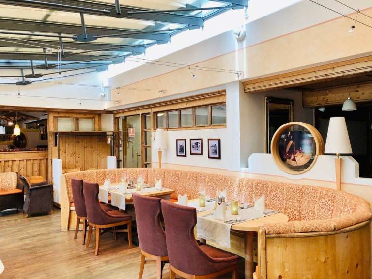 Ein Restaurant mit einem Tisch und Stühlen und Bildern an der Wand