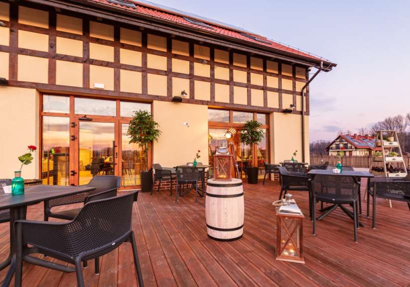 Eine Terrasse mit Tisch und Stühlen vor einem Gebäude