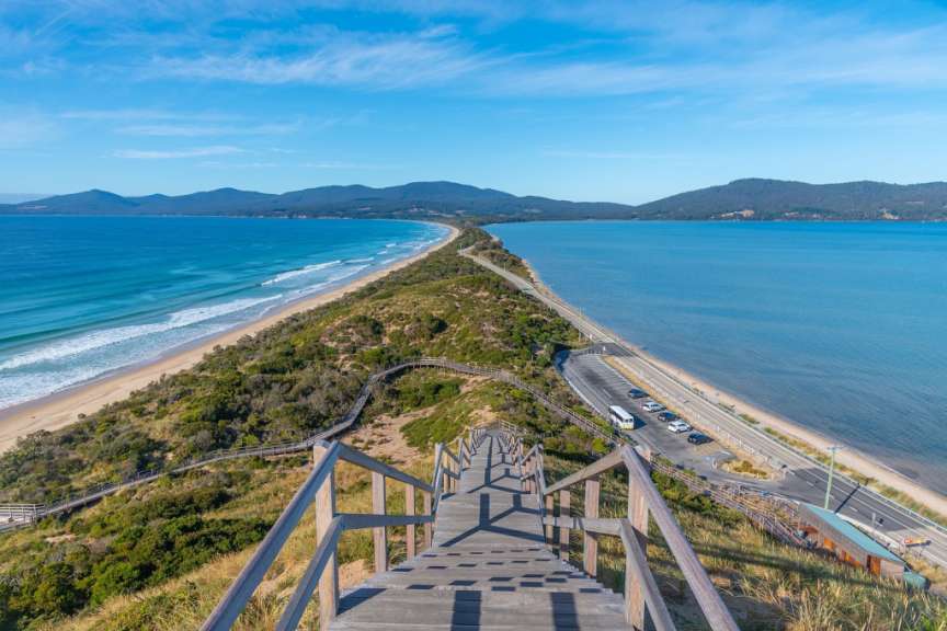 Eine Holztreppe führt hinunter zu einem Strand