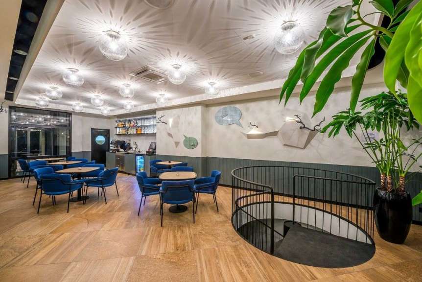 Ein Restaurant mit blauen Tischen und Stühlen und einer Treppe
