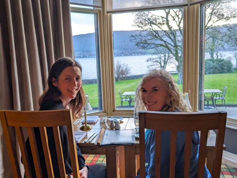 Blick aufs Wasser: Anna und Ingrid beim Frühstück Zwei Frauen sitzen an einem Tisch mit Blick auf einen See