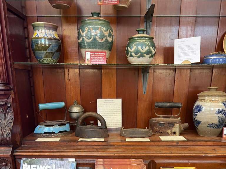 Ein Regal mit Vasen und einem Schild mit der Aufschrift „ very flat pottery “