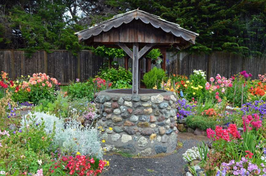 Ein Brunnen steht inmitten einer Blumenwiese